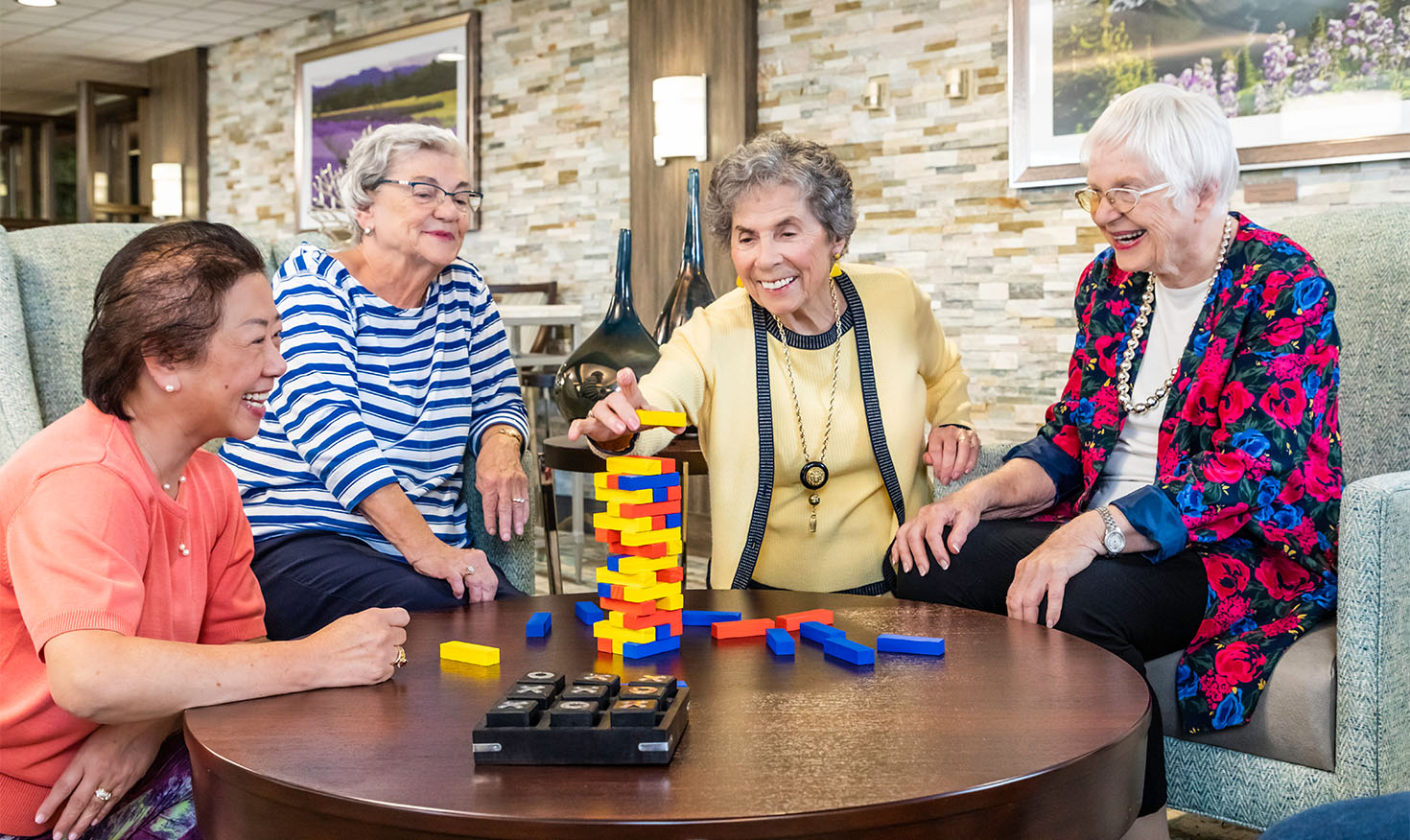 Group of four senior women playing a game of Jenga