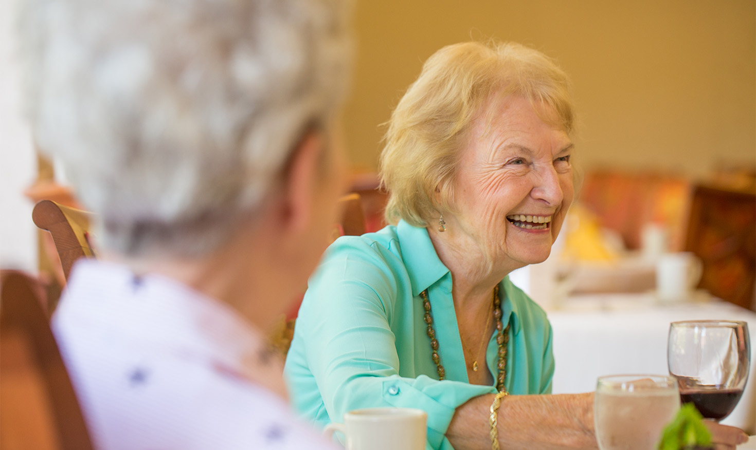 Senior woman enjoying a glass of wine with friends