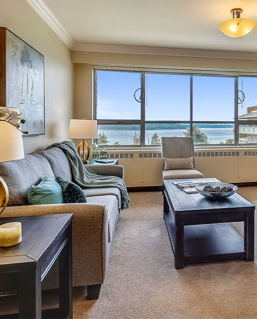 Living room of an apartment at Judson Park with views of the Puget Sound outside of the windows