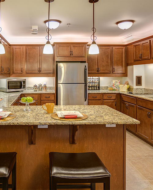 Interior of an apartment kitchen with wood cabinets and granite countertops