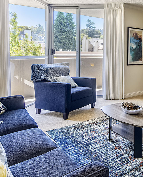 Living room of an apartment at Piedmont Gardens with a sliding glass door leading to a balcony