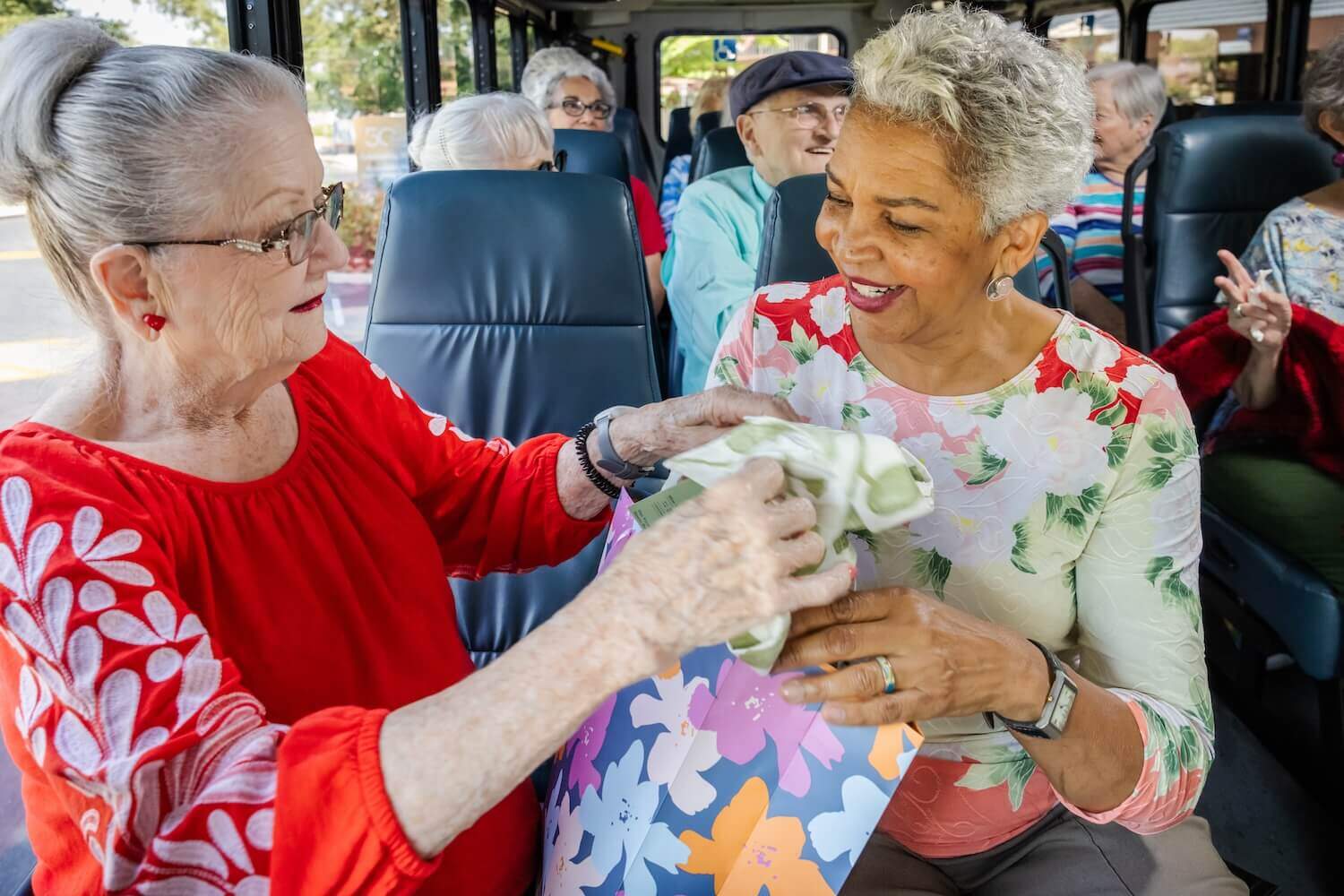 2 women, one is black, seated on excursion bus