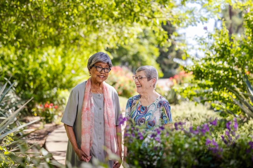 2 women surrounded by flowers