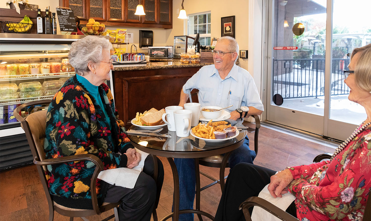 Two senior women and a senior man eating lunch at the cafe at Rosewood