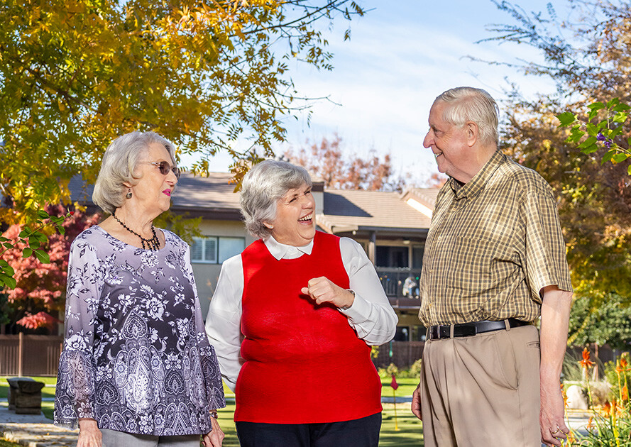 Two senior women and a senior man talking on a sidewalk in Rosewood