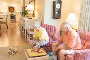 Senior couple playing Scrabble in their apartment at Royal Oaks