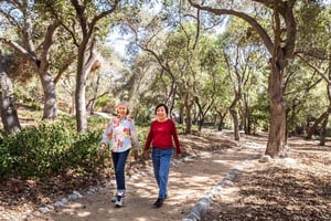Two senior women walking on a trail under the oak trees at Royal Oaks