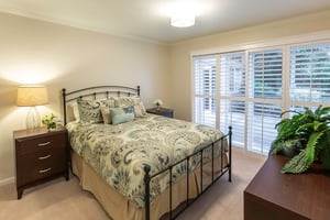 Large bedroom with flowery bedspread of an apartment at Royal Oaks