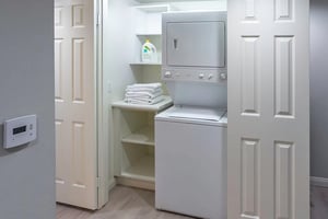 Laundry area featuring a stacked washer and dryer in an apartment at Royal Oaks