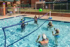 Group of seniors playing volleyball in the pool at Royal Oaks