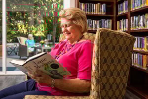 Senior woman sitting in an armchair reading the book 