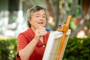 Senior woman painting outside