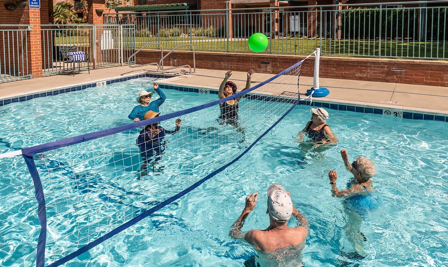 Group of seniors playing volleyball in the pool at Royal Oaks