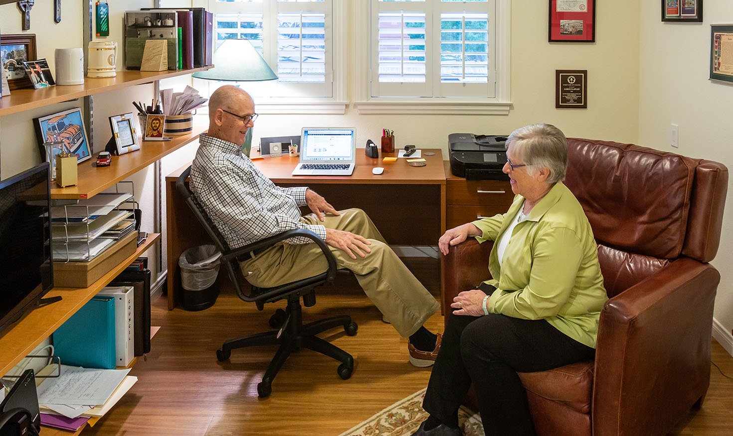 Senior couple sitting in the office of their apartment at Royal Oaks