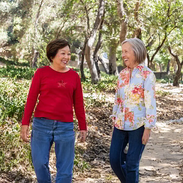 Two smiling senior women walking outdoors at Royal Oaks