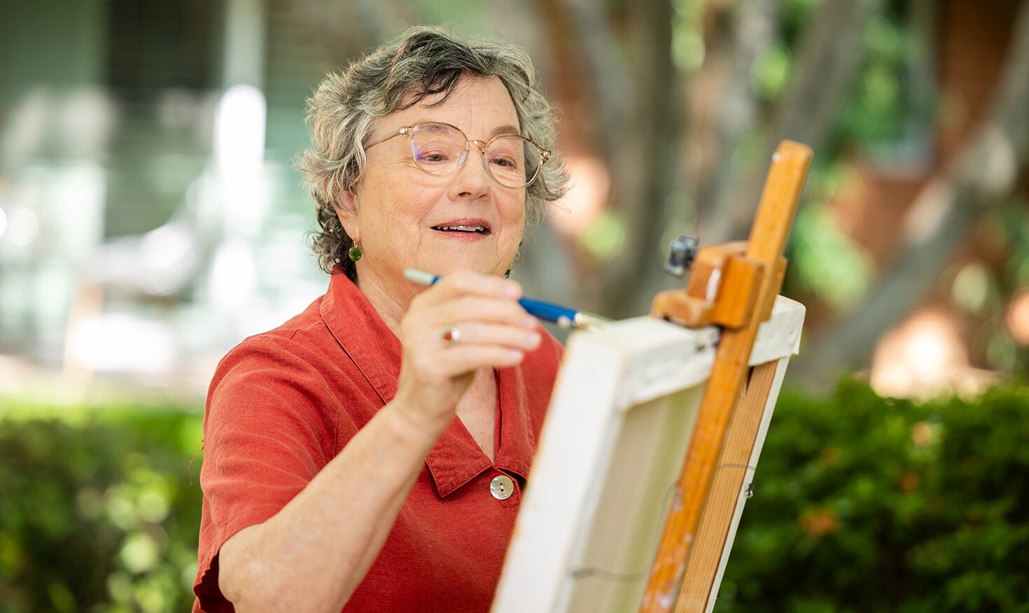 Senior woman painting outside