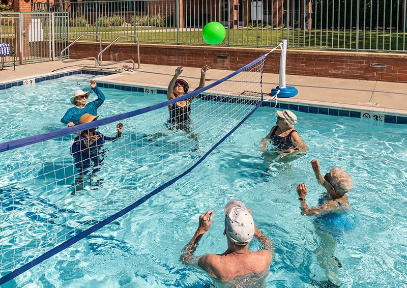 Group of seniors playing volleyball in the pool at Royal Oaks