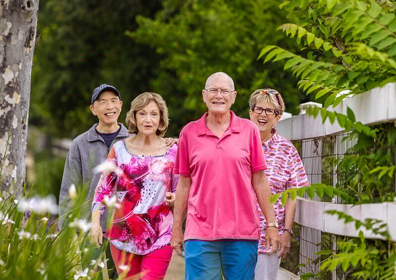 Two senior women and two senior men walking on the Royal Oaks campus