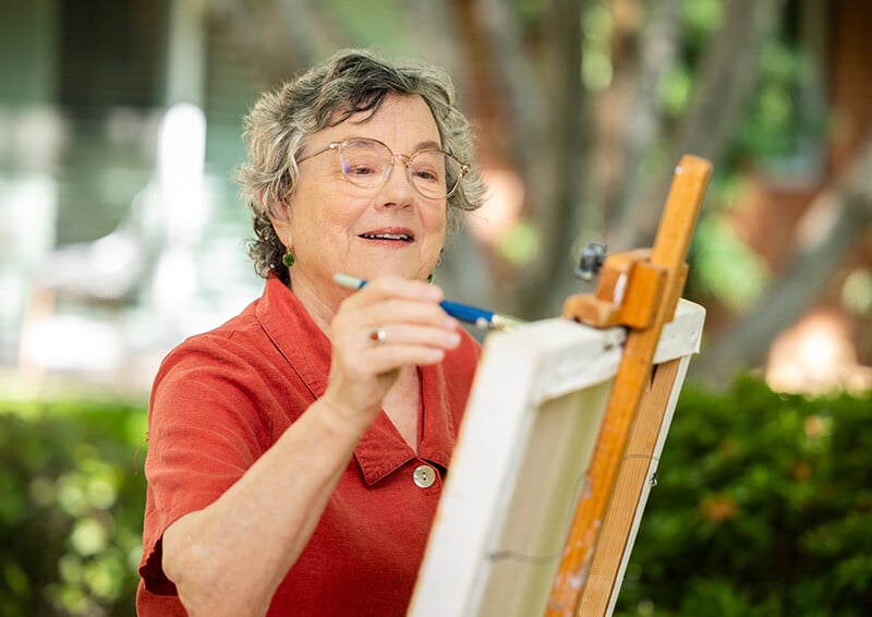 Senior woman painting outdoors