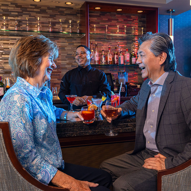 Senior man and woman enjoying drinks at the bar