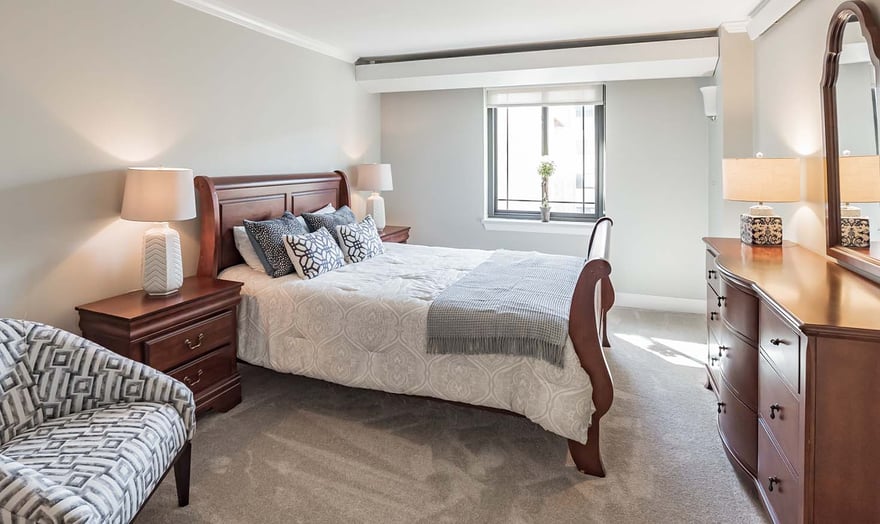 Bedroom of an apartmentWhite kitchen with stainless steel appliances in an apartment at Rydal Park & Waters