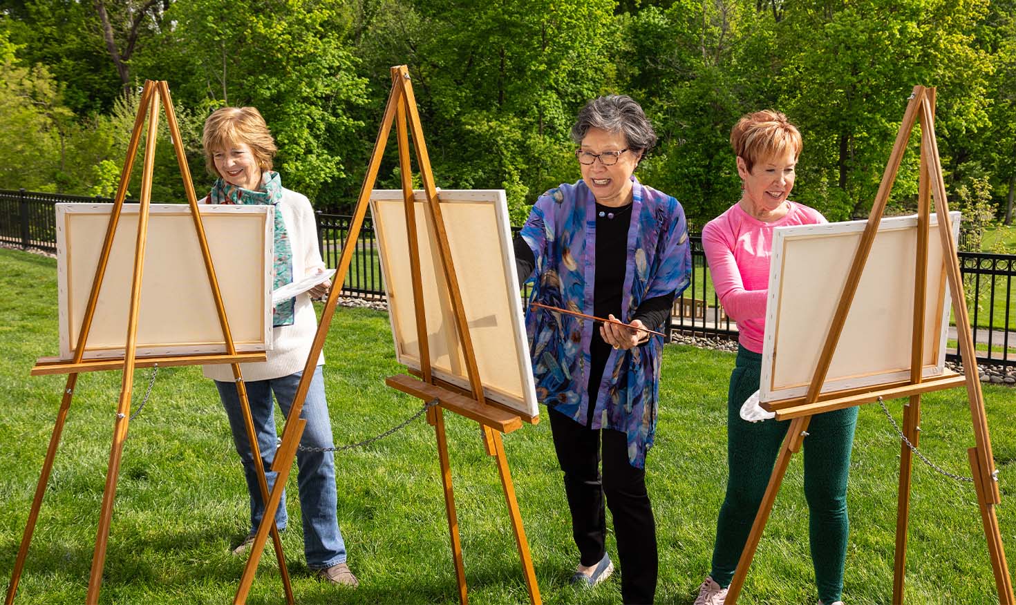 Three senior woman painting outside