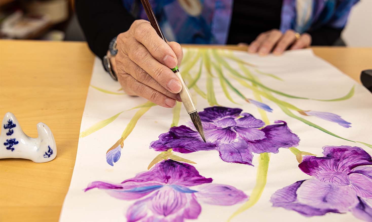 Close-up of hands painting purple flowers