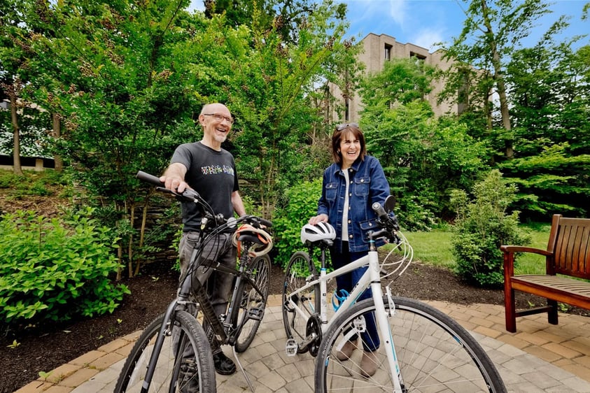 Senior man and woman standing next to bicycles
