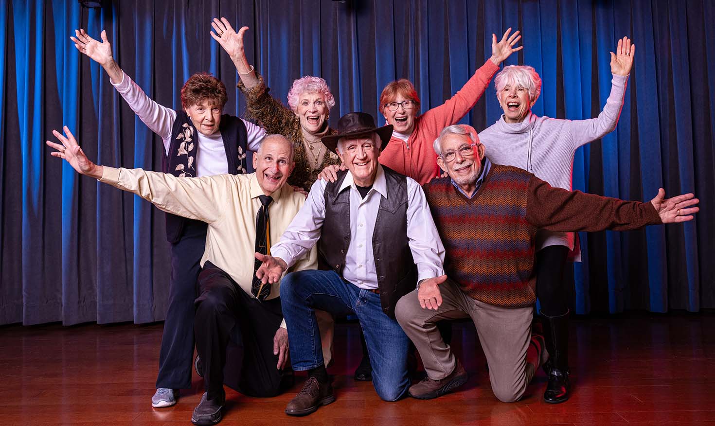 Group of seniors in front of a blue curtain onstage