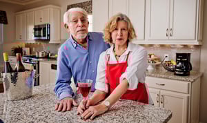 Senior couple standing at an island in the kitchen of their home at Rydal Park & Waters