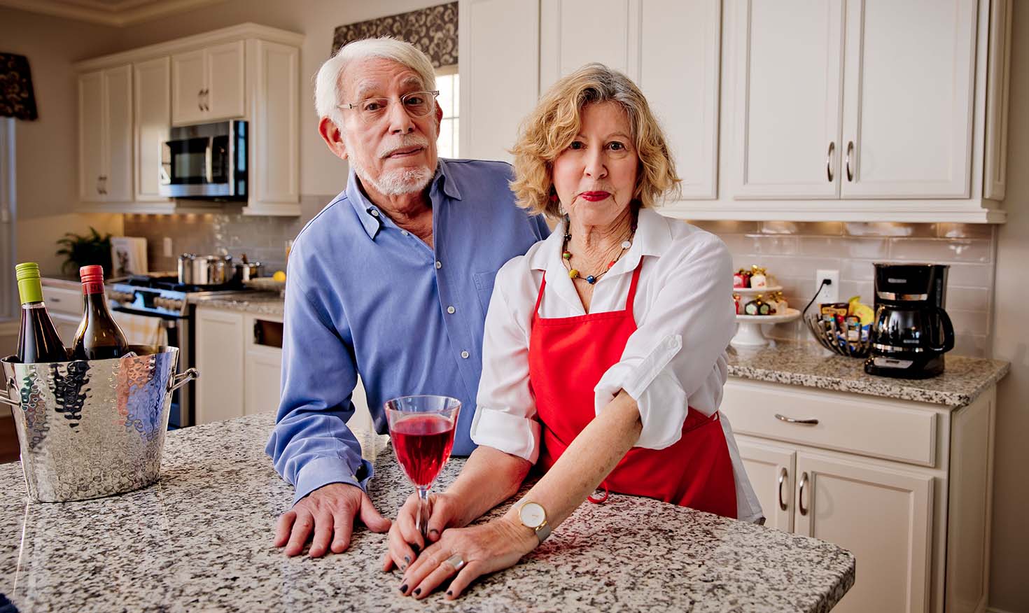 Senior couple standing at an island in the kitchen of their home at Rydal Park & Waters