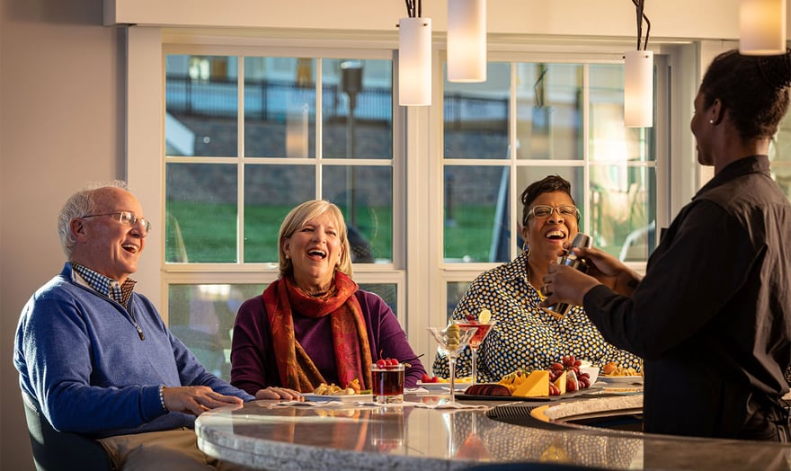 Three seniors and bartender laughing at the clubhouse bar