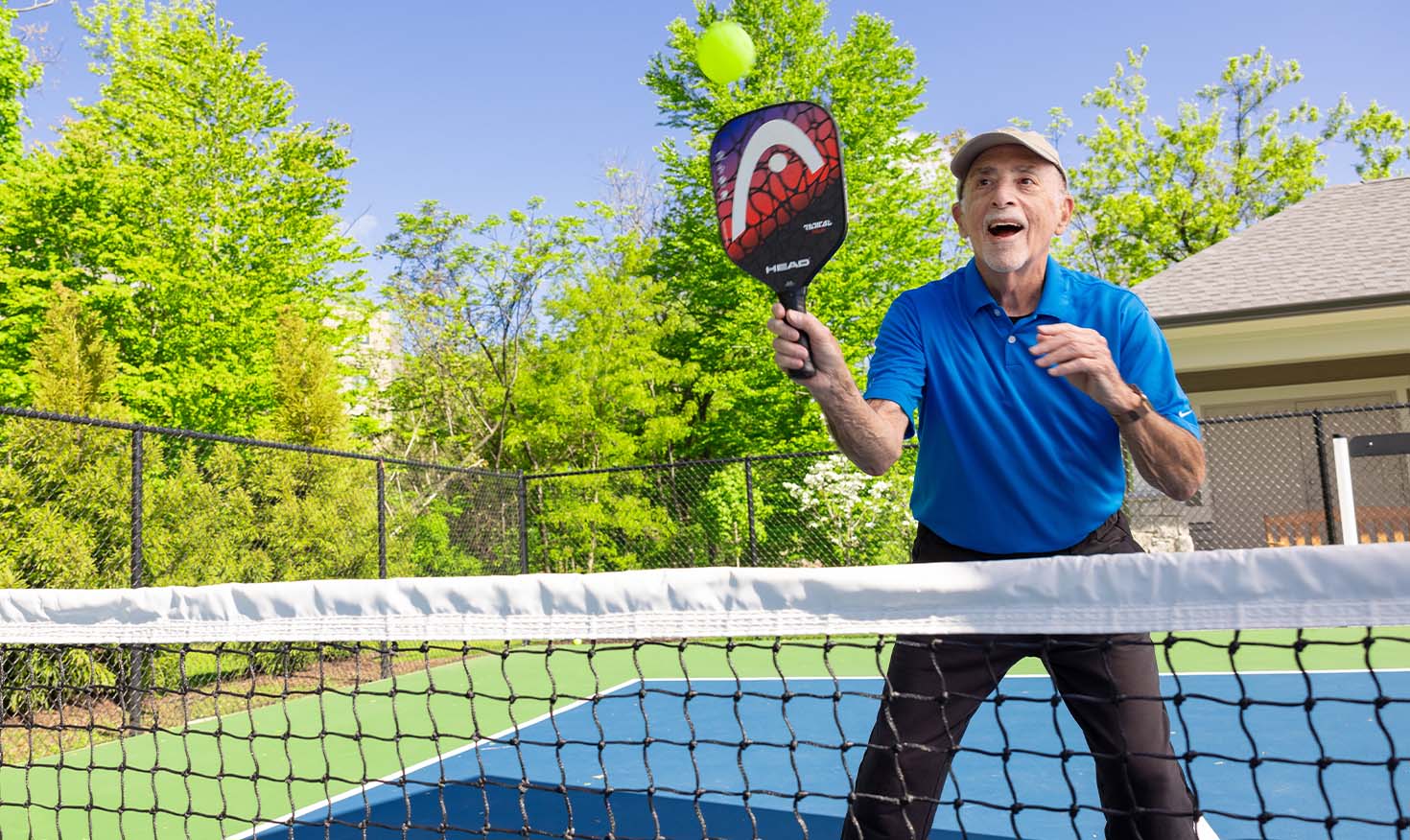 Senior man playing pickleball on an outdoor court