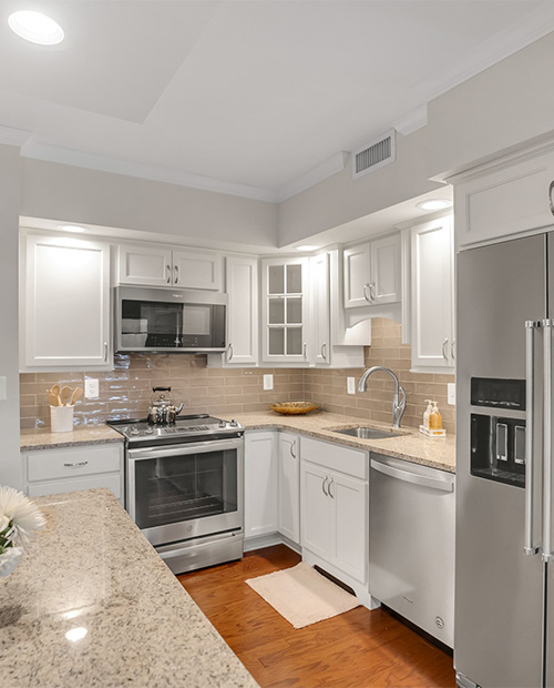 White kitchen with stainless steel appliances in an apartment at Rydal Park & Waters
