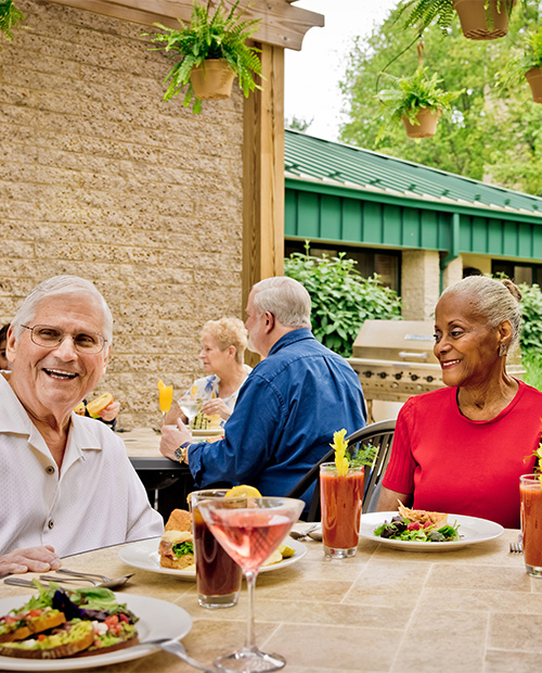 Senior friends having lunch on an outdoor patio