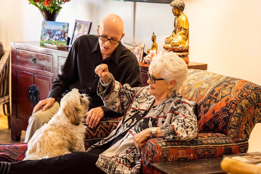 Senior couple sitting with their small dog in their apartment at The Terraces at Los Altos