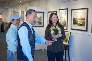 Senior couple at an art gallery talking with a gallery employee