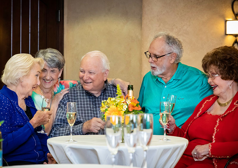 Group of five seniors with Champagne glasses