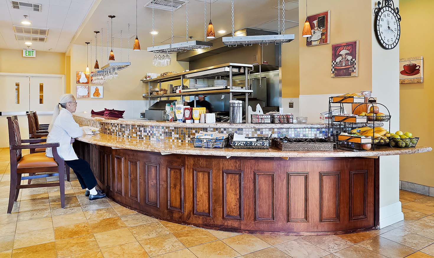 Interior of a bistro with a senior woman sitting at the counter