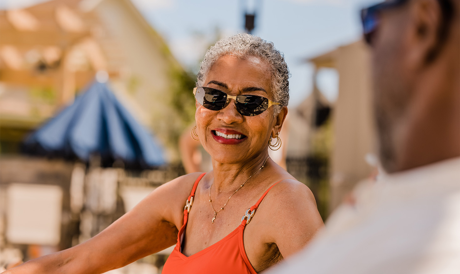 Senior women sitting outside wearing a swimsuit and sunglasses