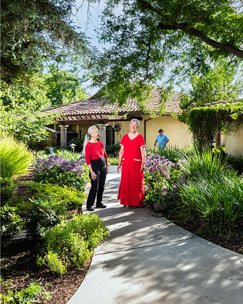 Two senior women standing outside and talking