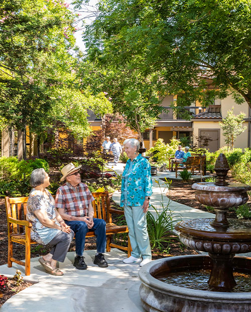 Three seniors having a conversation in an outdoor courtyard