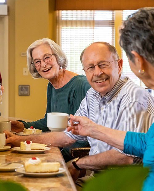 Seniors eating dessert and having coffee together