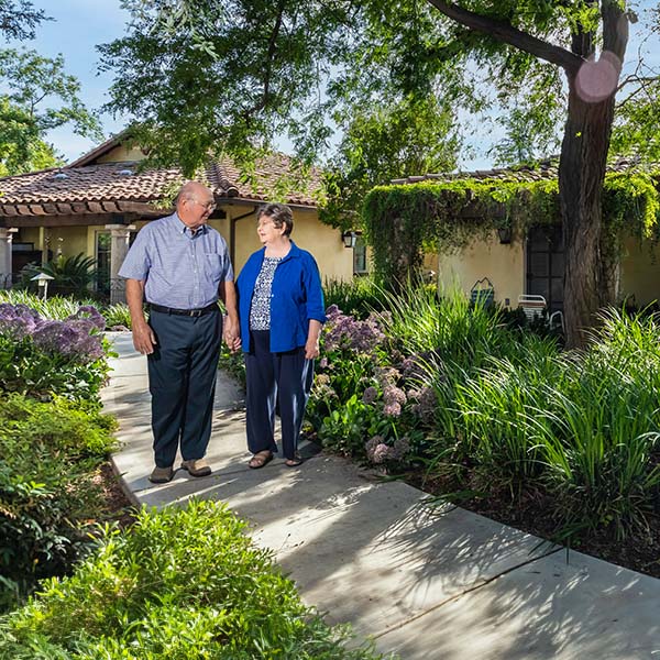 Senior couple walking through a paved garden