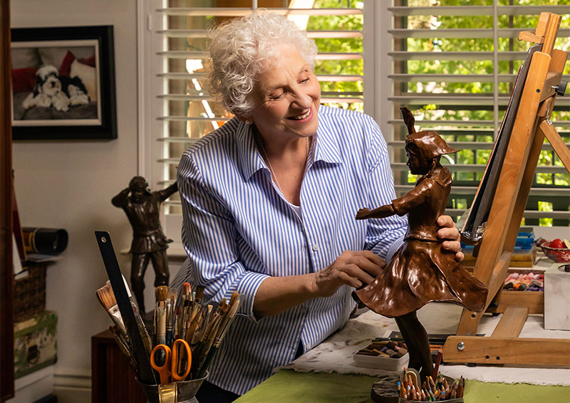 Senior woman with small bronze sculpture