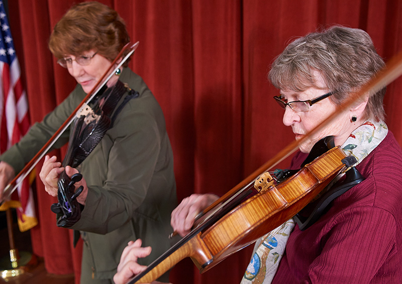 Two senior women playing violins