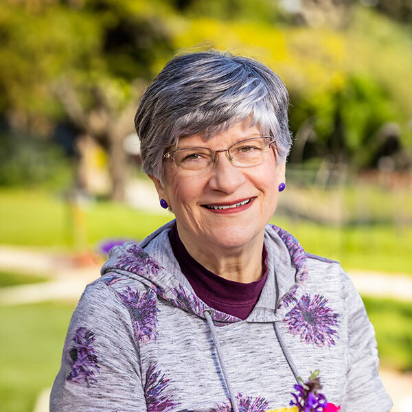 Smiling senior woman sitting outdoors at The Terraces at Summitview