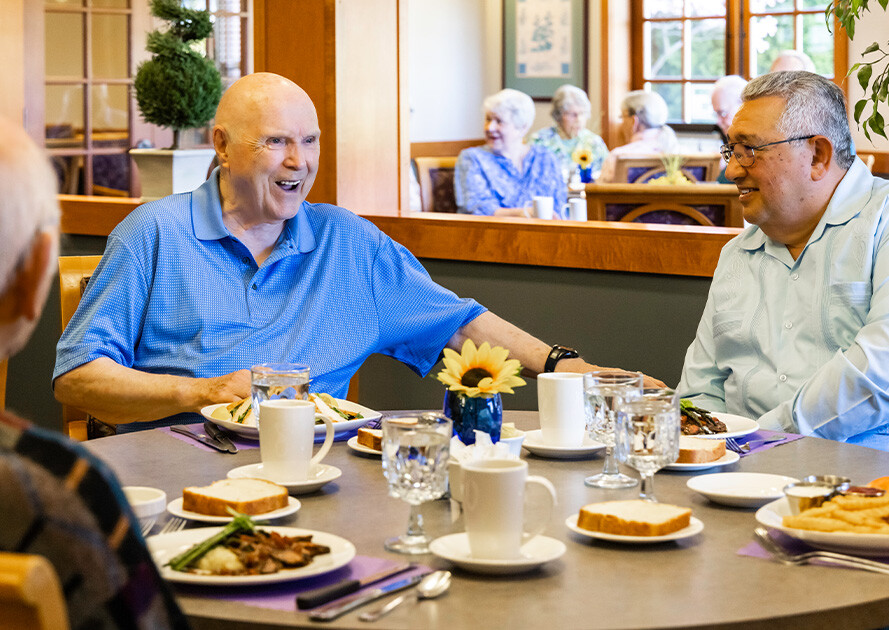 Three senior men eating lunch in The Terraces at Summitview dining room