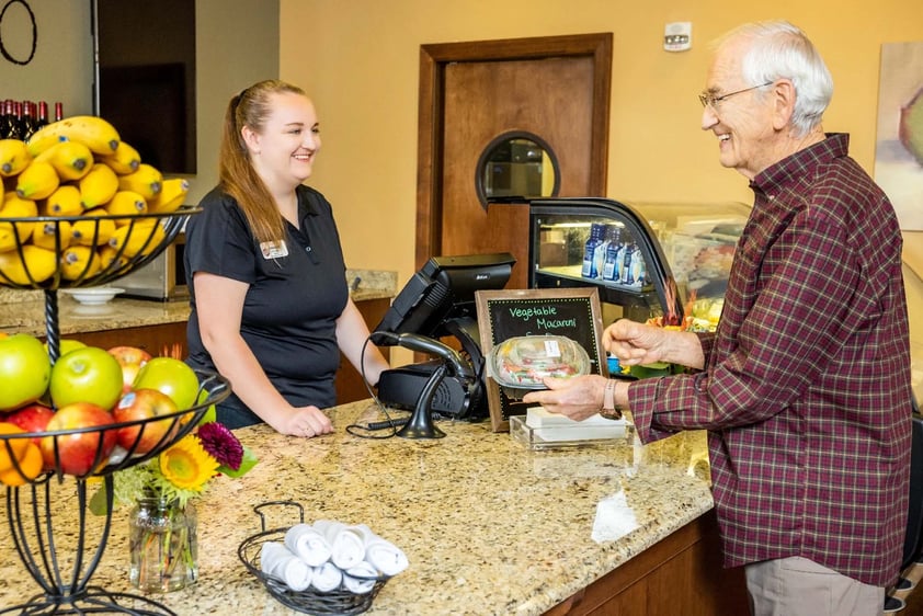 Senior man buying food from a female employee at The Terraces of Boise bistro