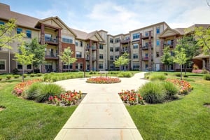 Walking path with a circular garden and apartment building at The Terraces of Boise